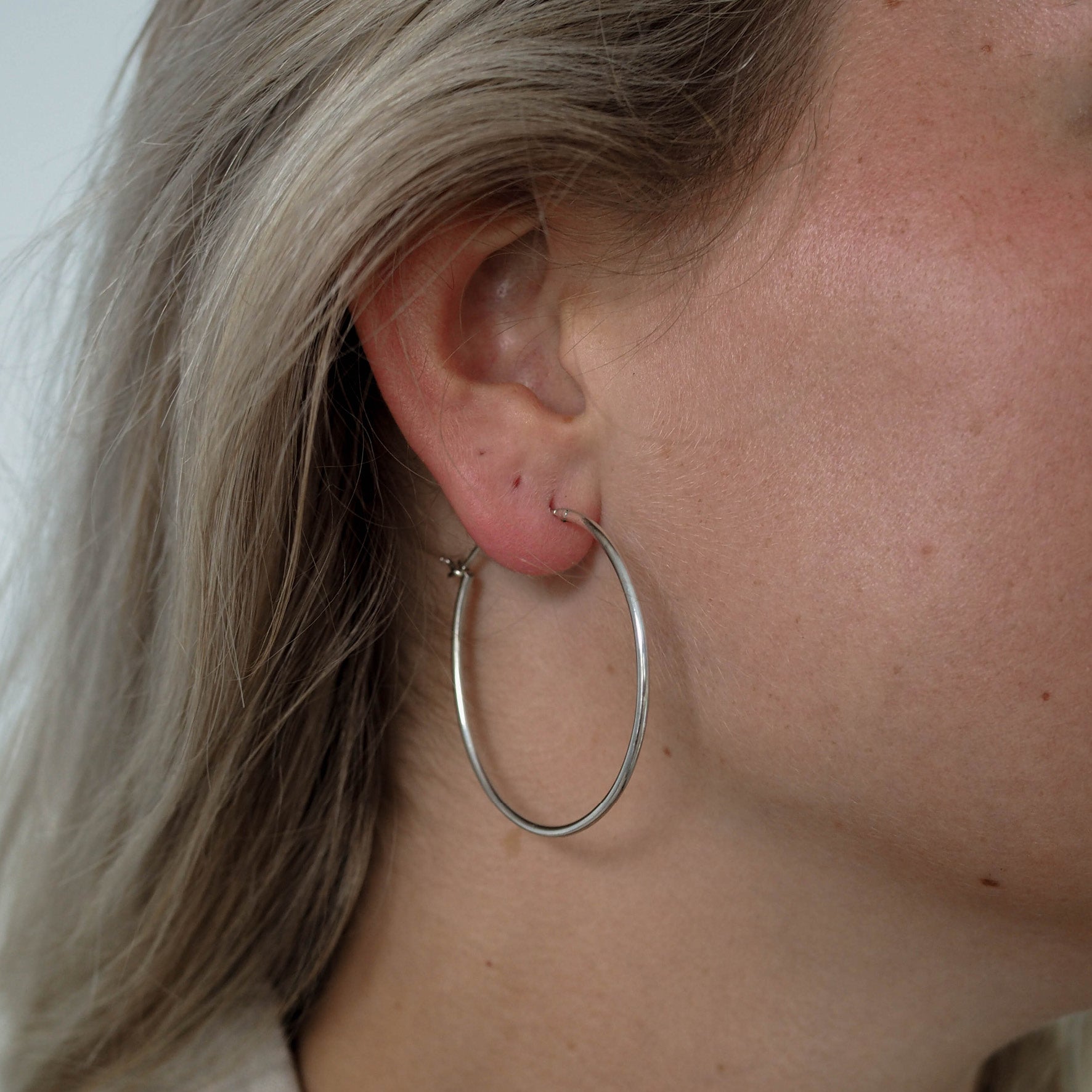 a woman wearing hoops earring silver 40mm