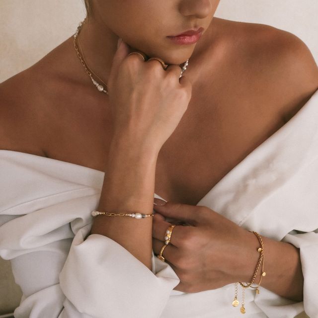 Classic white pearl bracelet styled with a shiny gold ring