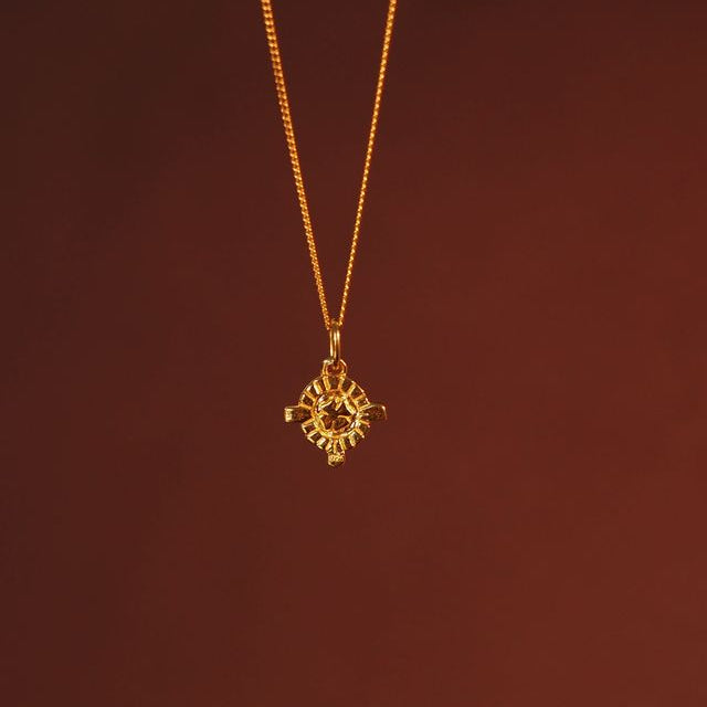Close-up of a hanging mini St. Dymphna charm gold