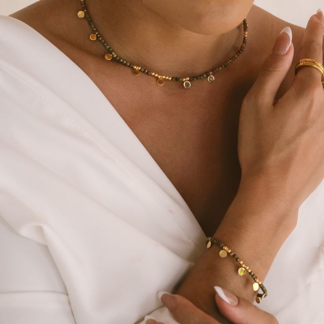 Close-up of a jewelry set featuring a beaded bracelet and droplet necklace