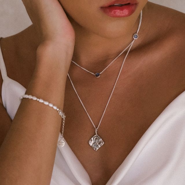 Close-up of a sparkling gemstone set in a silver chain necklace and bracelet