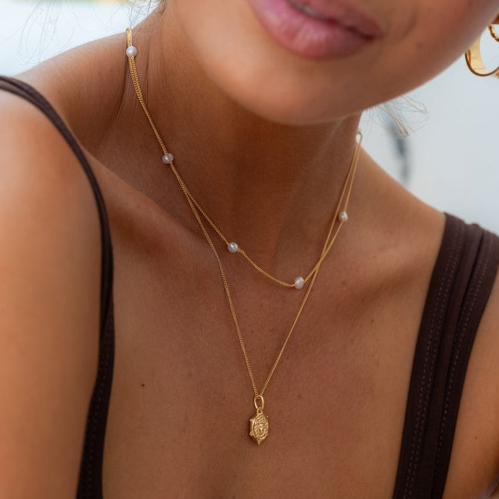 Elegant woman showcasing a delicate mini Medusa pendant
