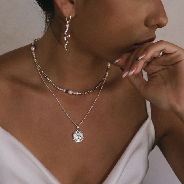 Fashion-forward layered necklaces with mixed rings and earrings