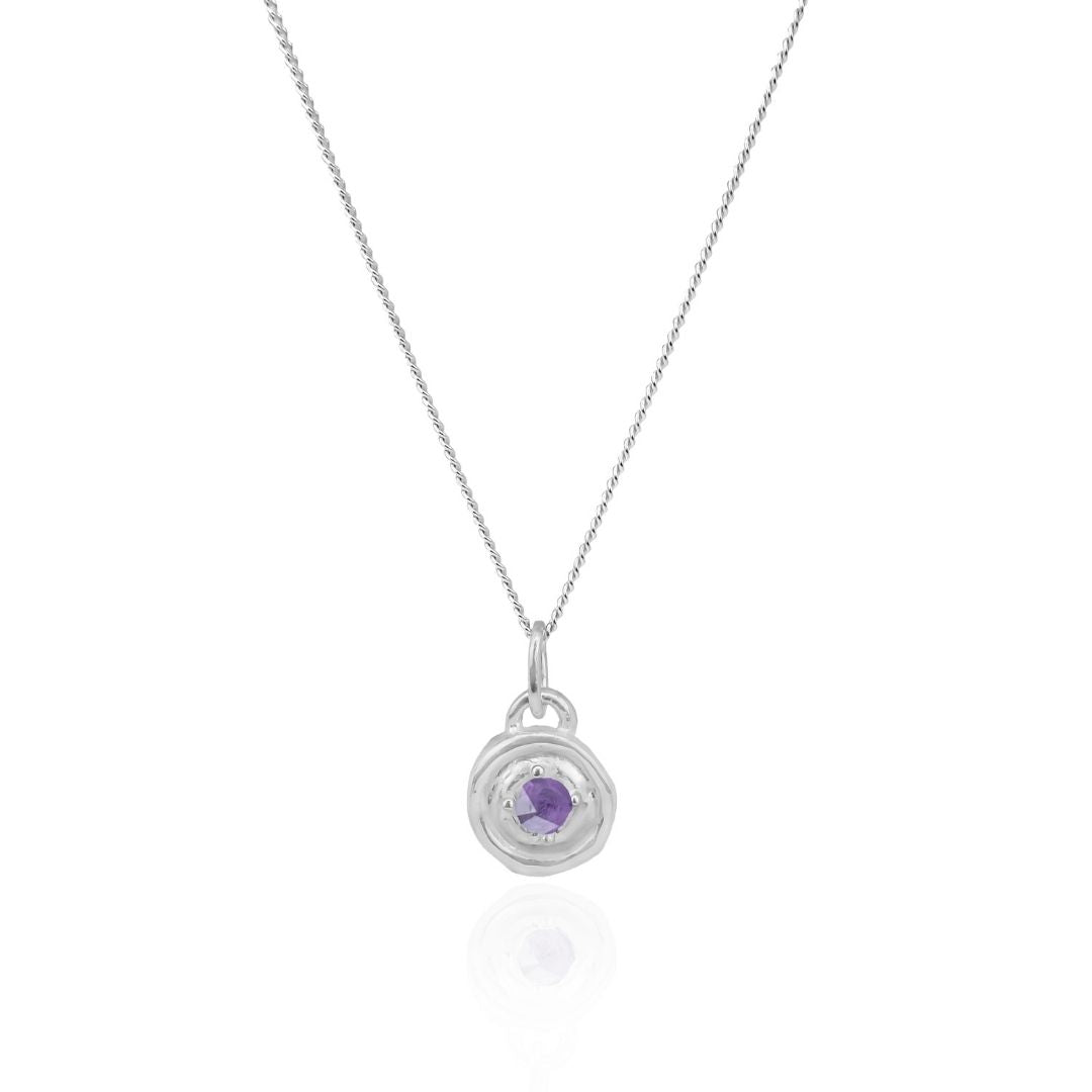 Silver necklace with a round pendant featuring a purple gemstone on a white background