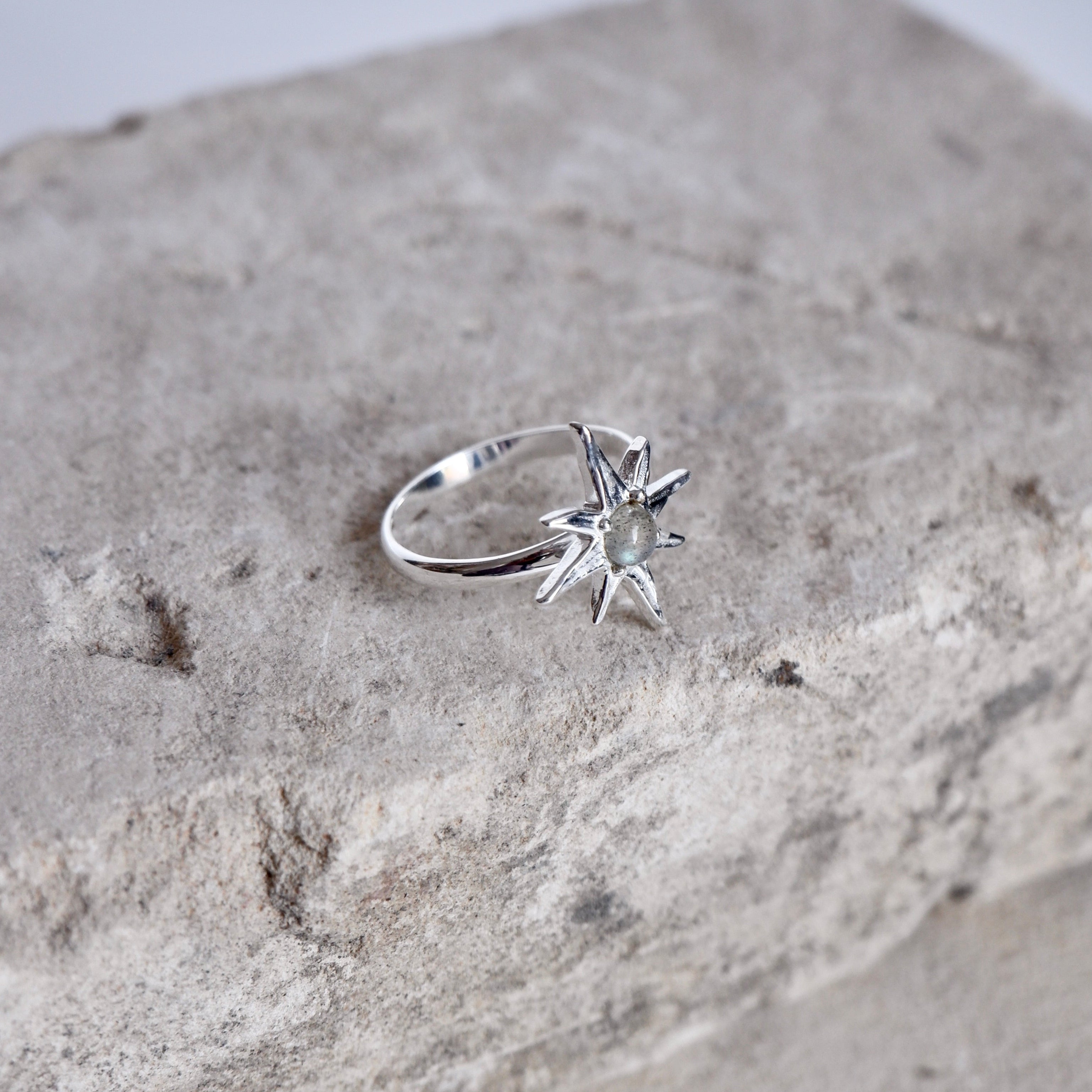 Flat lay of Handmade Luna & Rose x Tahnee Kelland ‘I Told You About the Stars’ silver ring, featuring celestial star details and labradorite stones, crafted in Bali.