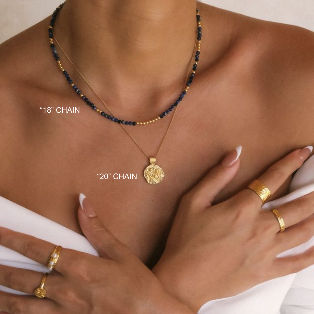 Gold necklace with pendant on a person's neck, hands wearing gold rings, with text indicating chain lengths.