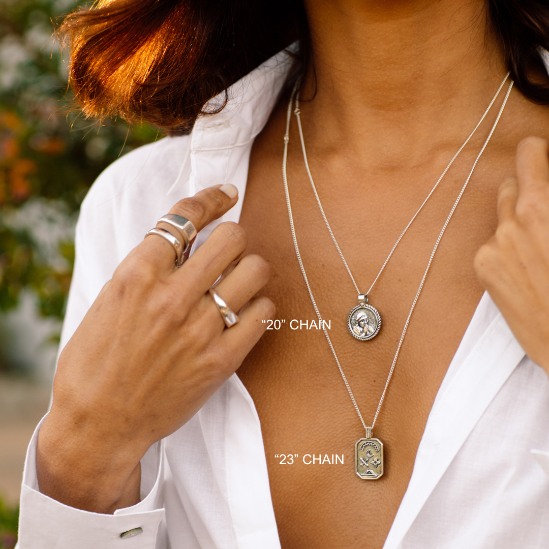 Person wearing two necklaces with chain lengths labeled, one hand adjusting a necklace.