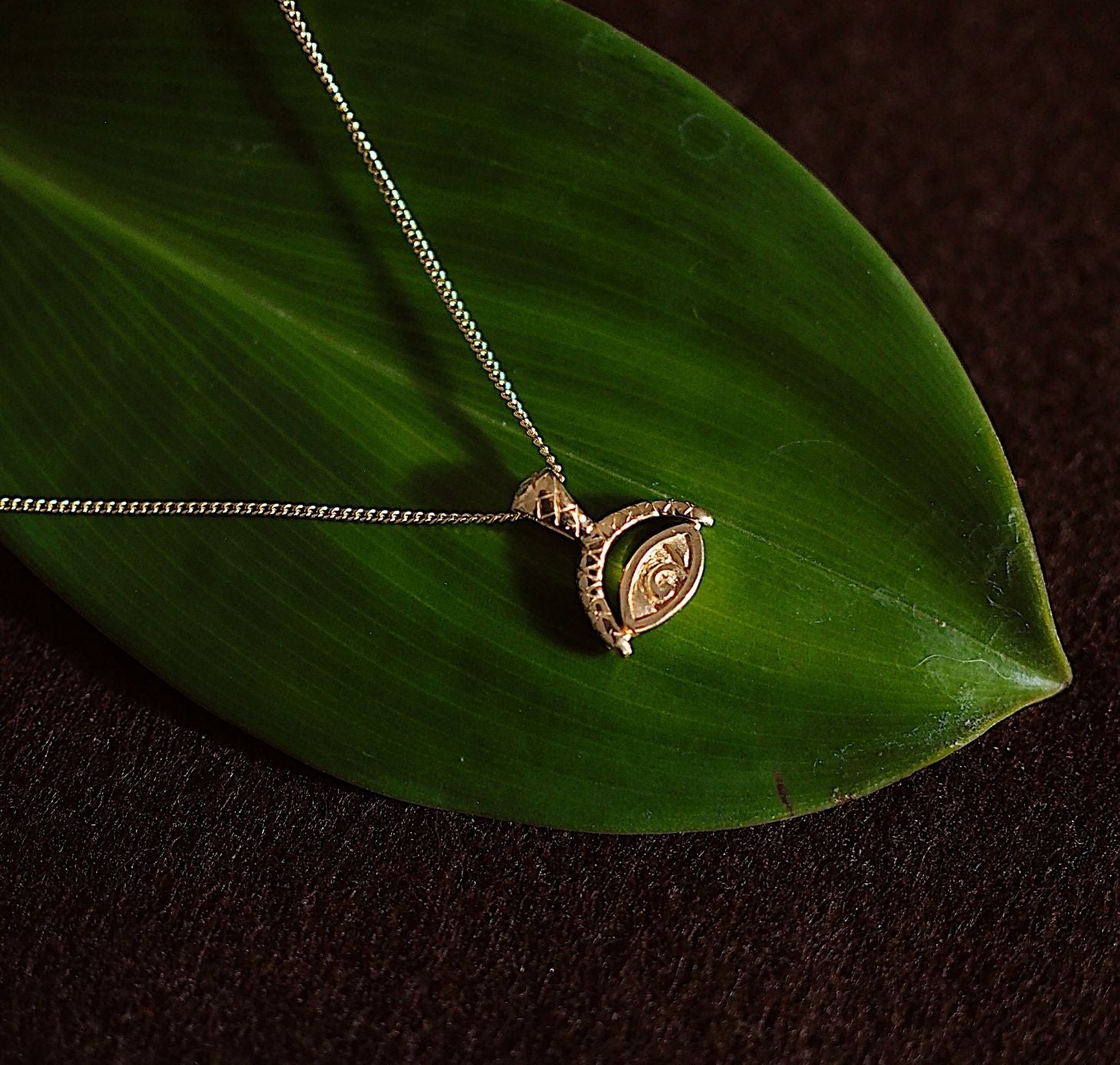 Protection Evil Eye Necklace - Gold on green leaf