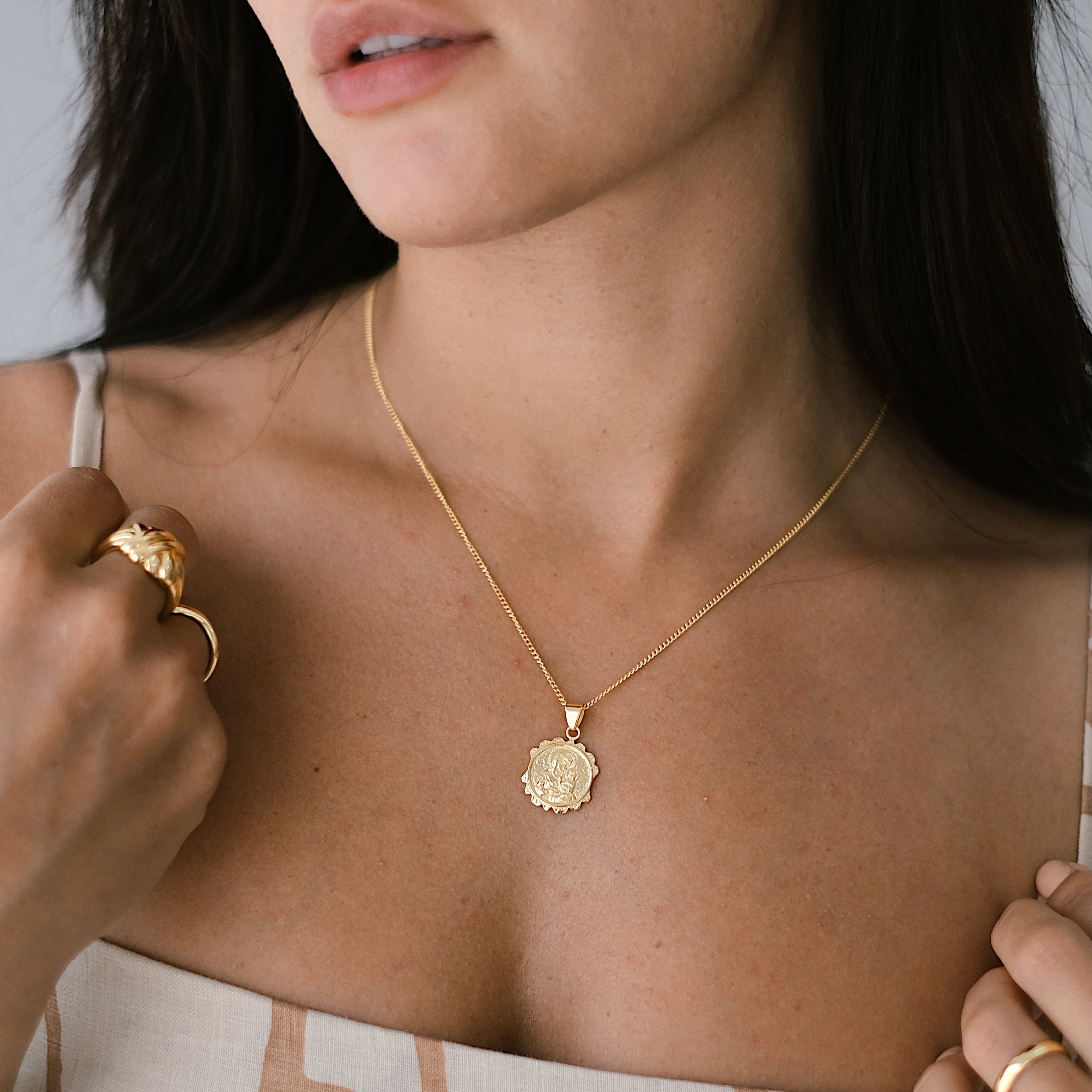 a woman with linen dress wearing St Anne necklace gold