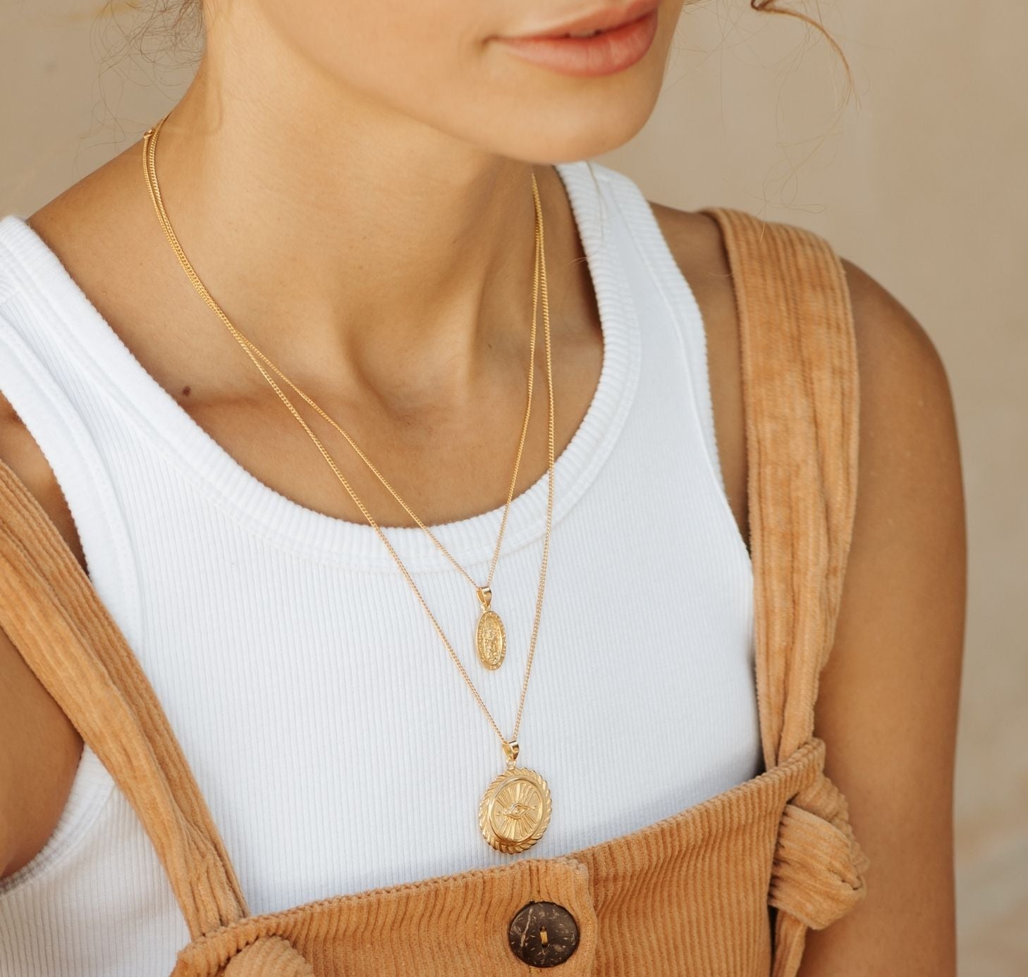a woman wearing two layers St Christopher and Suzanne necklace gold