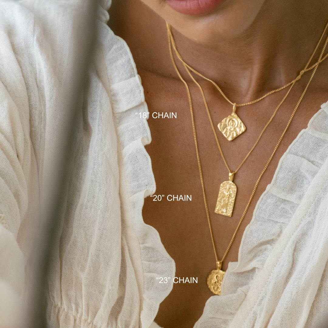 Gold necklaces with labeled chain lengths on a person wearing a white garment.