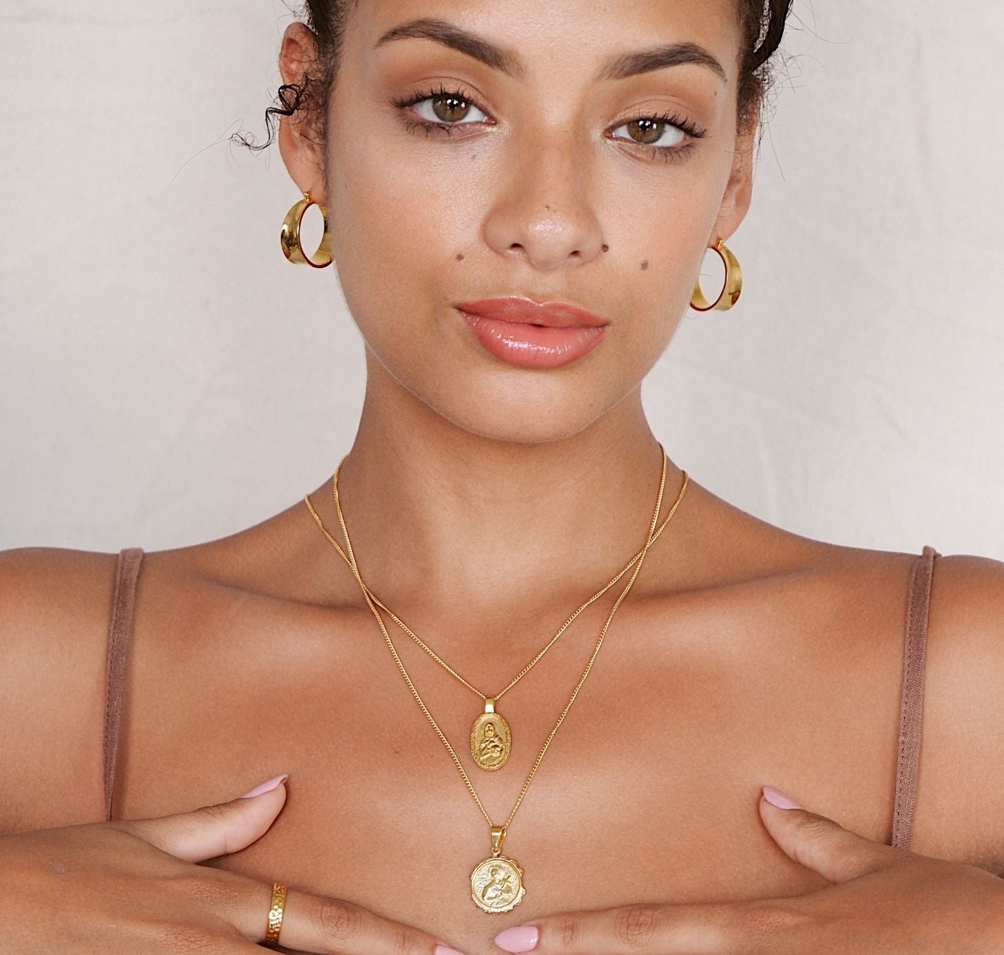 a woman wearing two layers necklace gold and Matilda hoops earrings gold