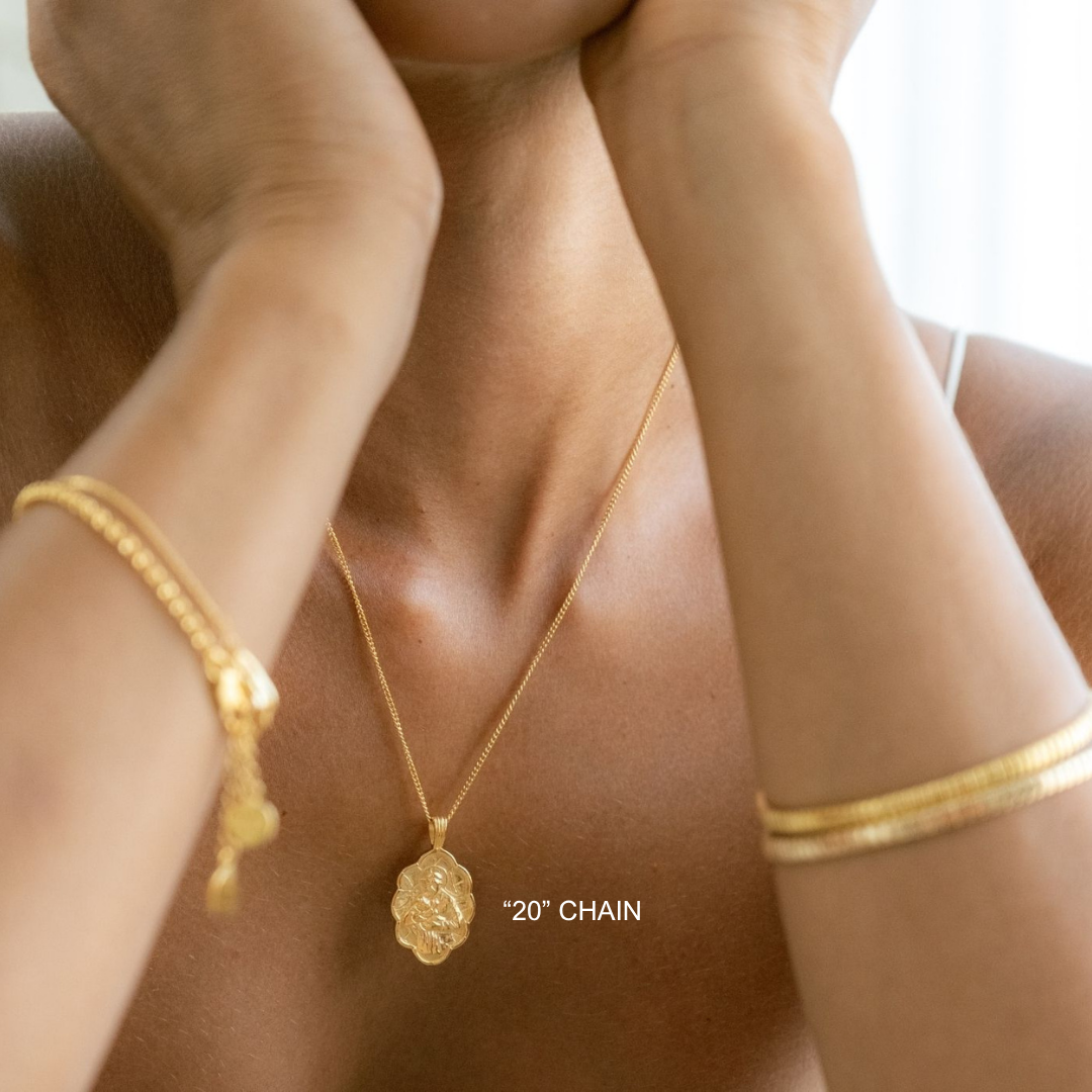 Gold necklace and bracelet on a person with '20' Chain text