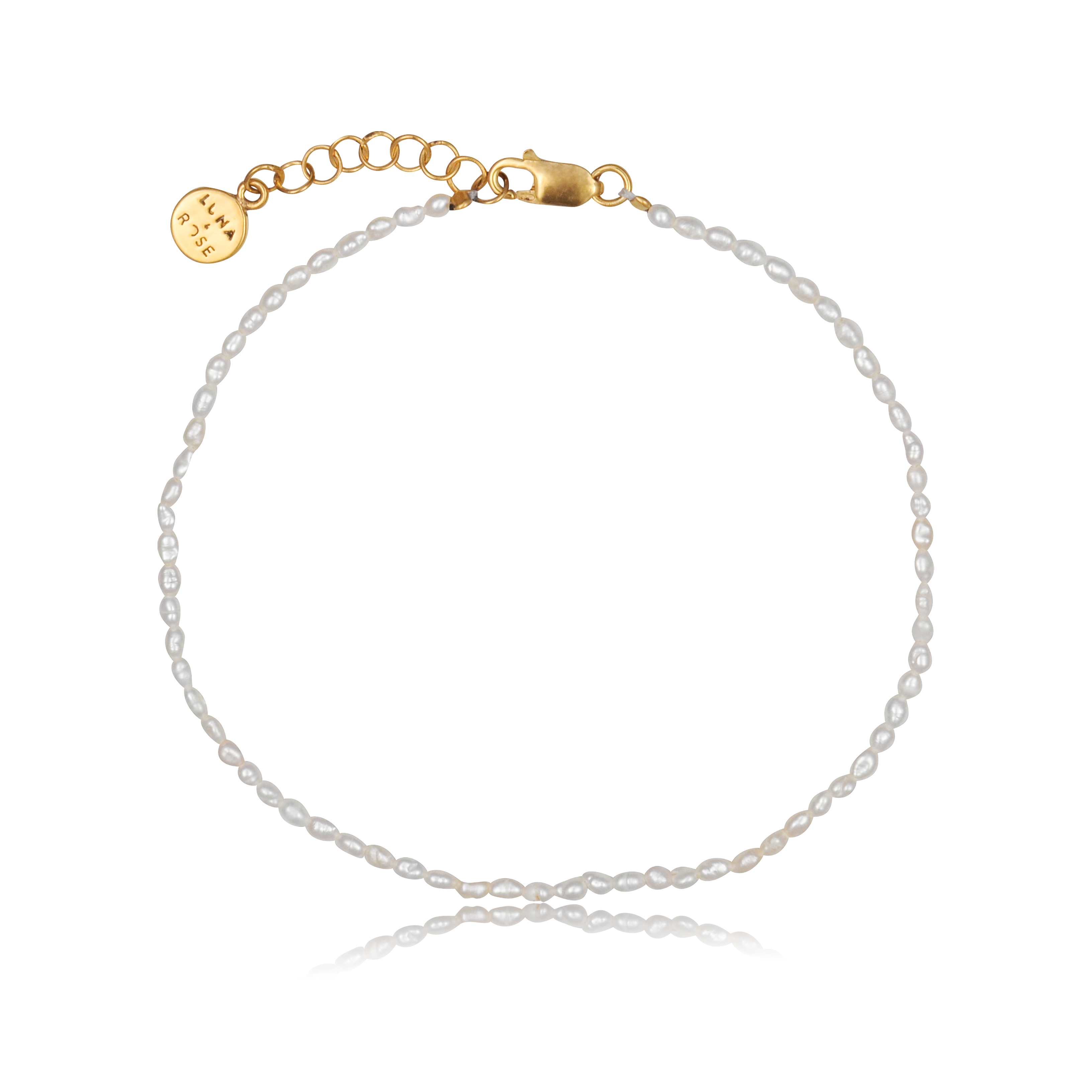 a piece of Timeless mini pearl bracelet gold on white background