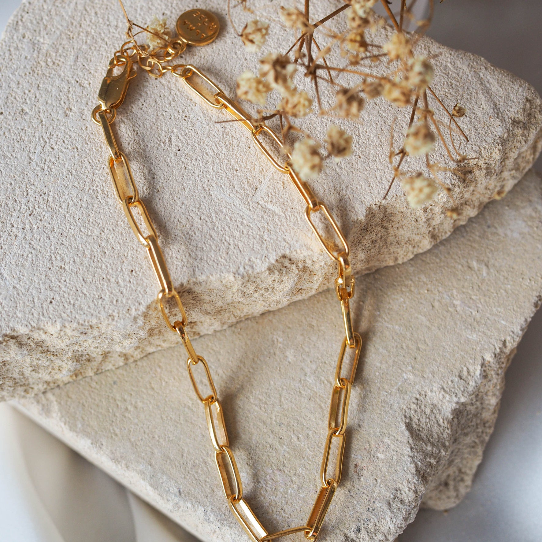 Washington Paper Clip Bracelet - Gold displayed on stone with dried flowers