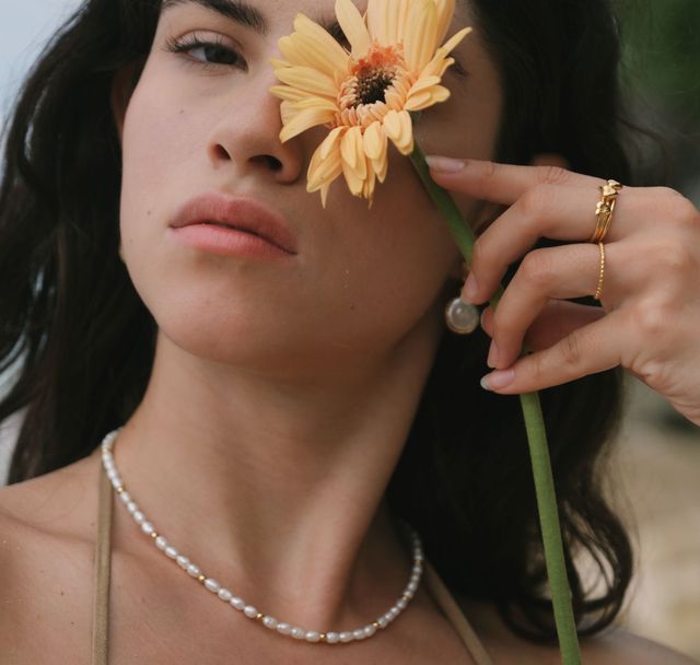 a woman with orange flower wearing The Remi necklace