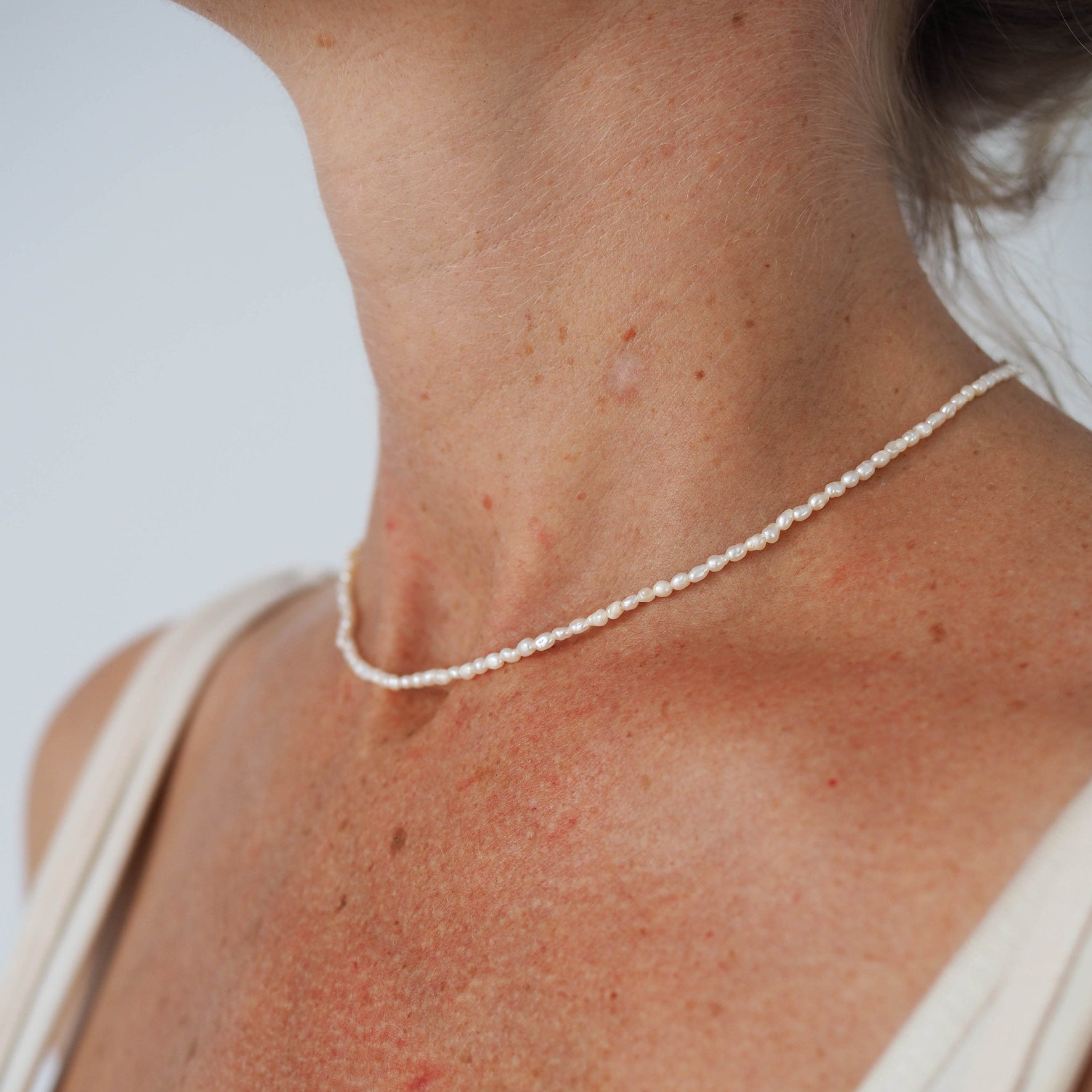 a woman wearing timeless mini pearl necklace silver on her