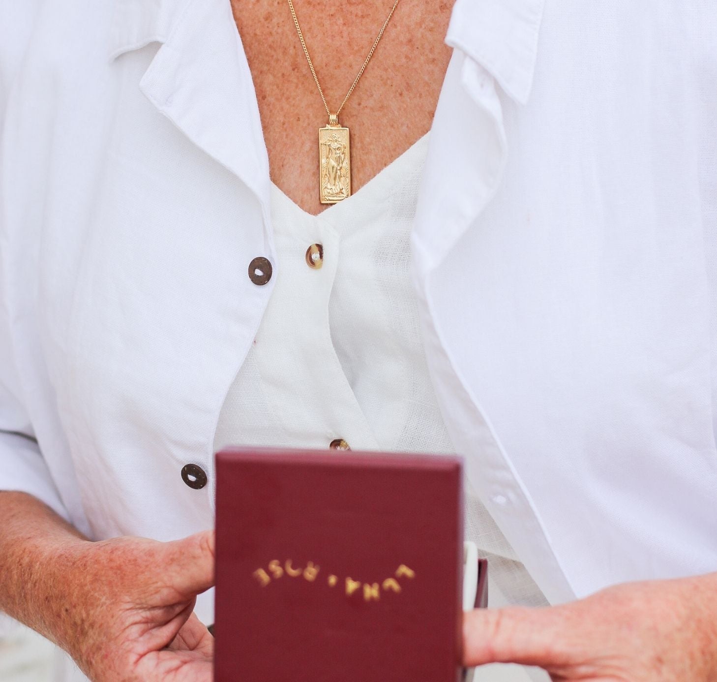 a woman with white shirts holding jewelry packaging