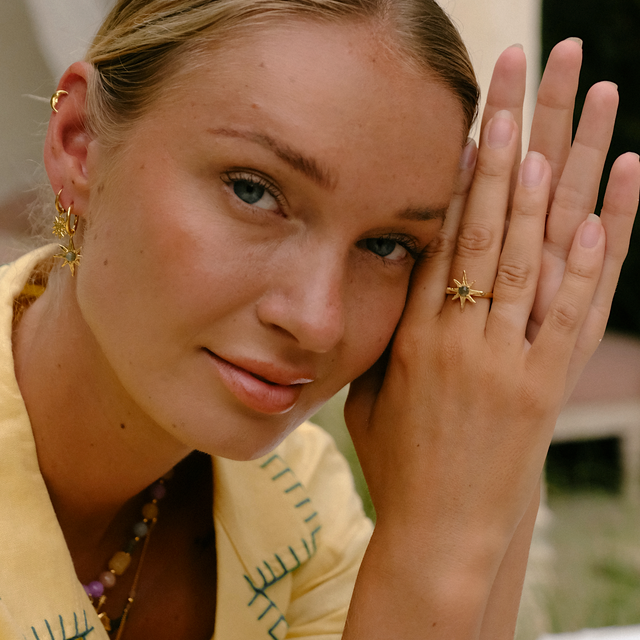Sunlit portrait of a woman adorned with gold jewelry