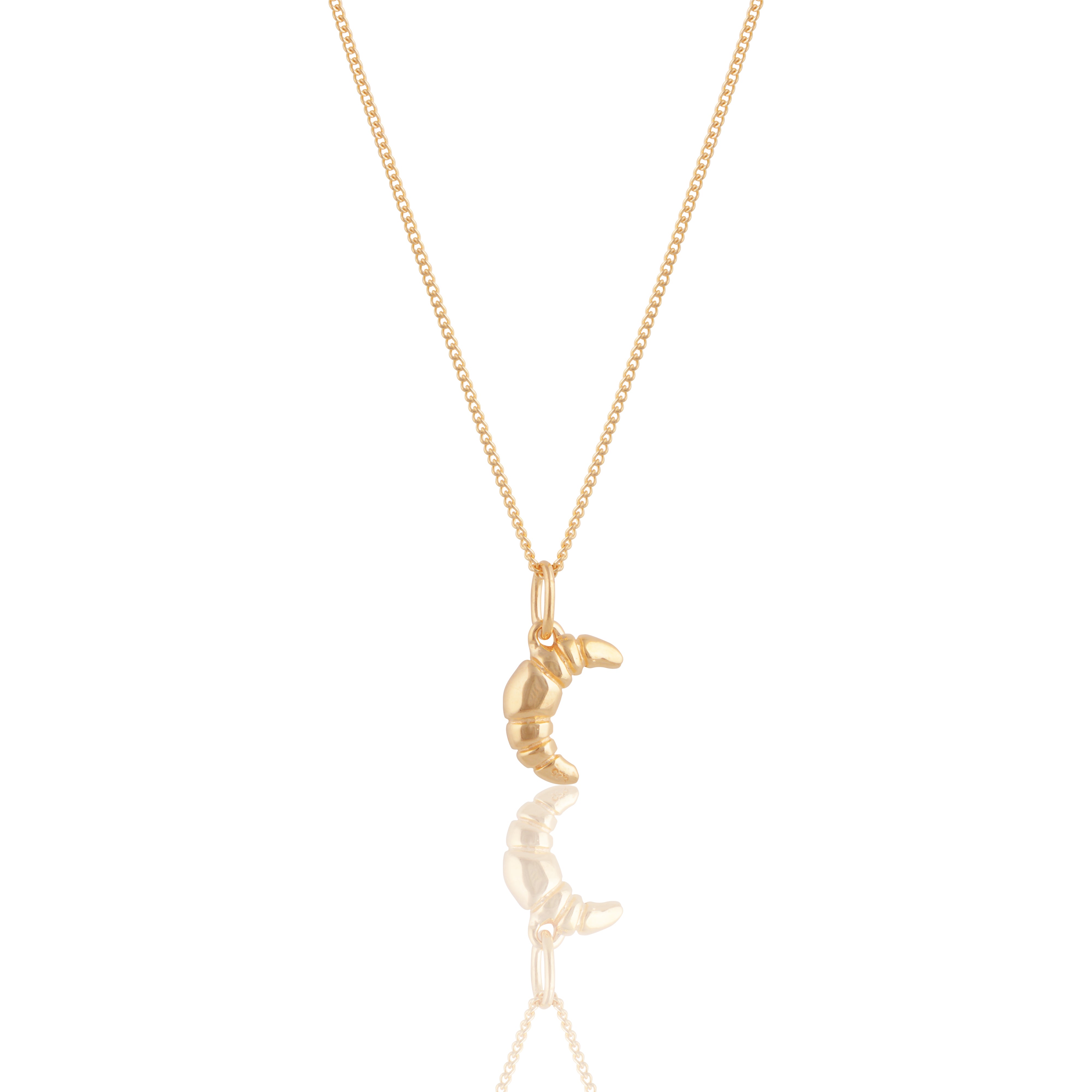 Mini Croissant Necklace in Gold from the ACME x Luna & Rose collection, a dainty croissant-shaped pendant for an elegant and playful touch.