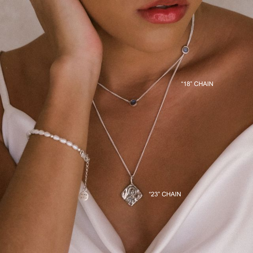 Close-up of a woman wearing two necklaces with chain lengths labeled, against a neutral background.