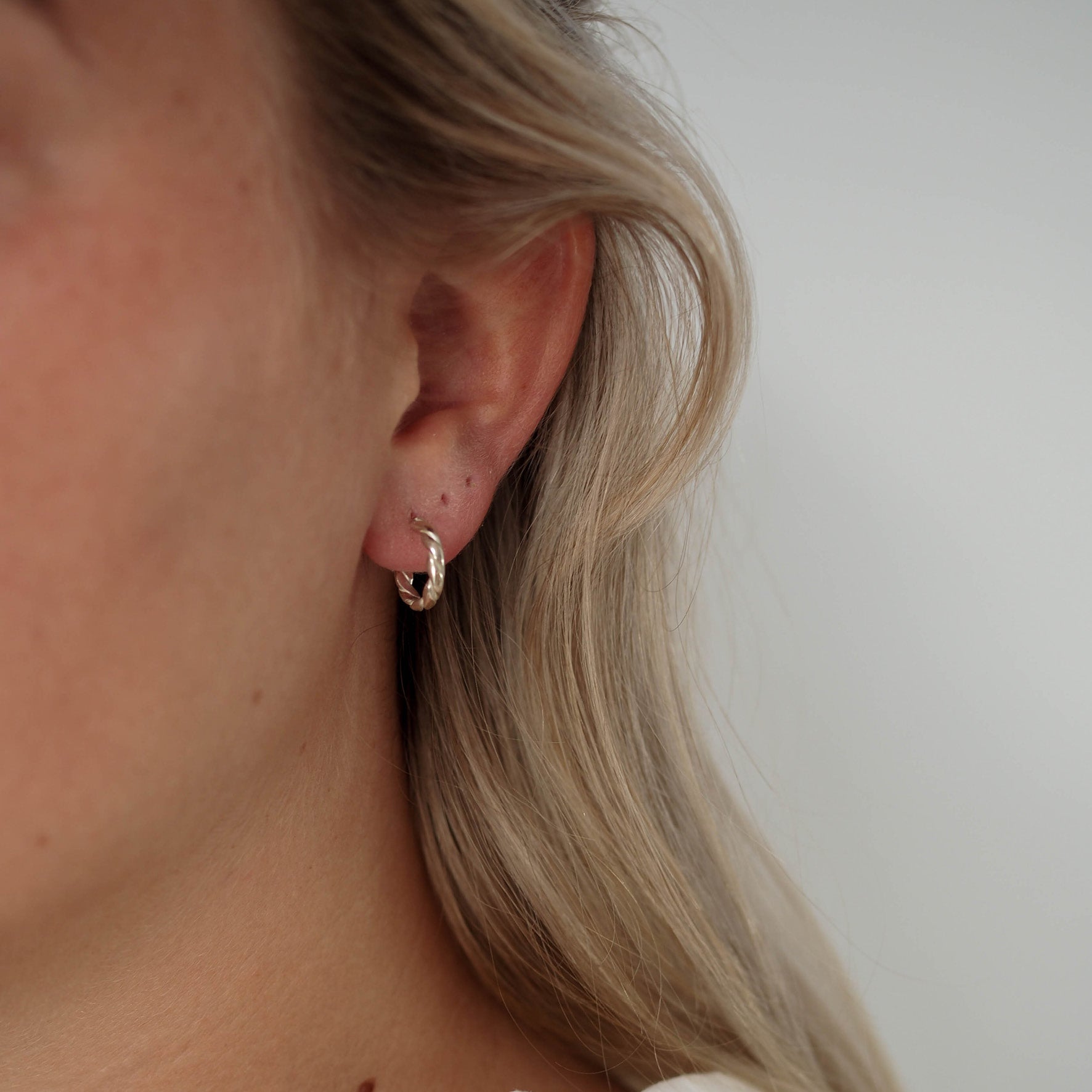 a woman wearing The Hudson twisted hoops earrings
