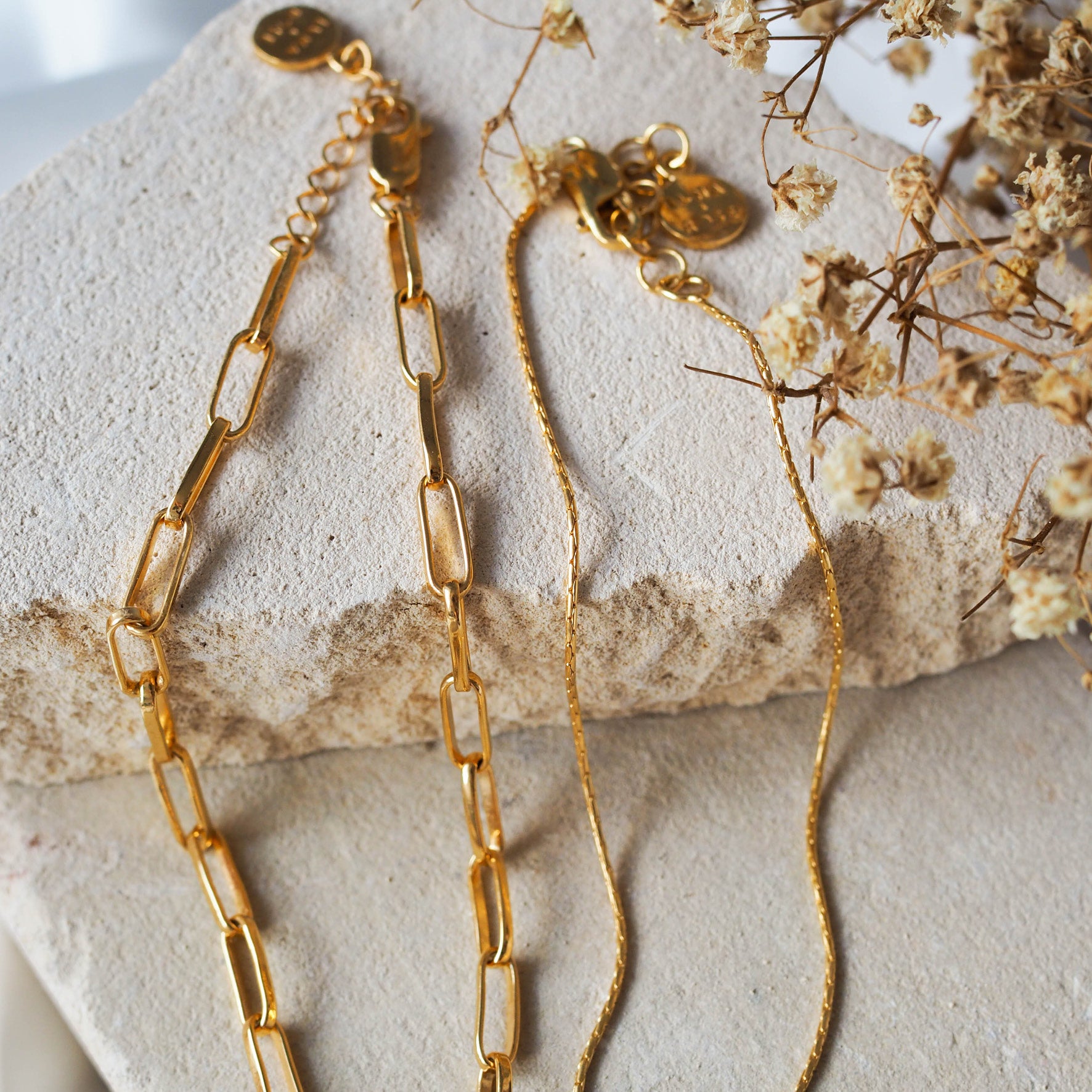 Washington Paper Clip Bracelet - Gold displayed on stone with High Line fine chain bracelet gold