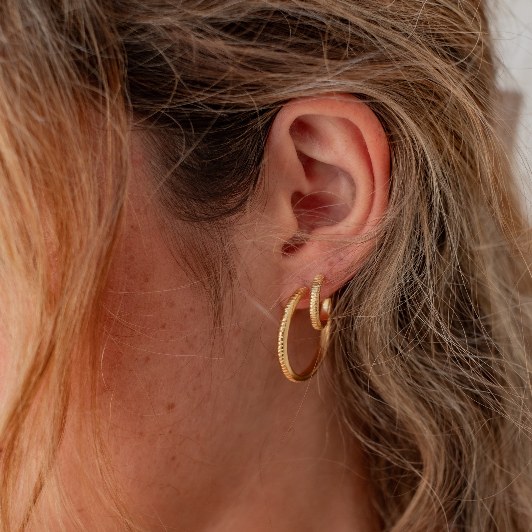 The MET Stripe Thin Earrings Gold in two sizes on woman
