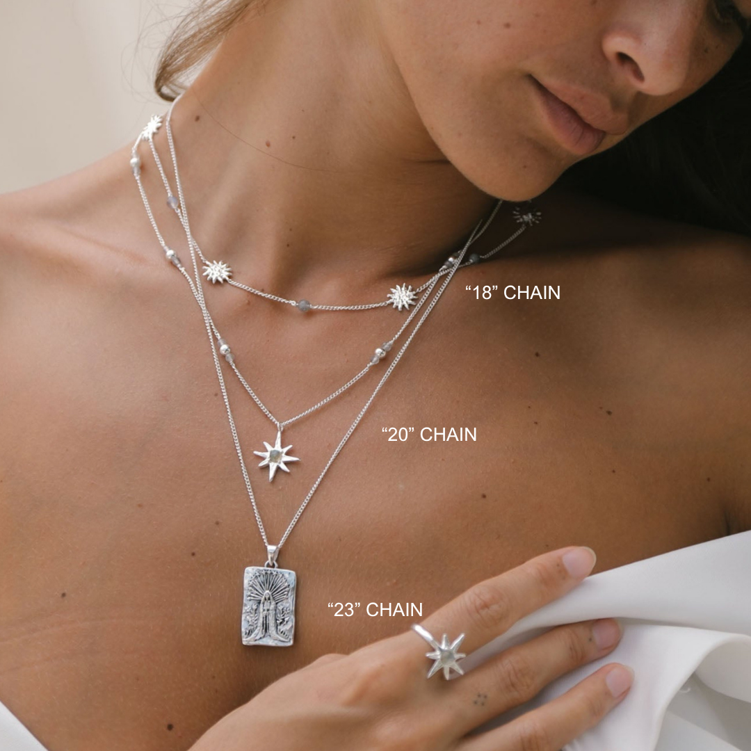 Close-up of a person wearing layered silver necklaces with chain lengths labeled.