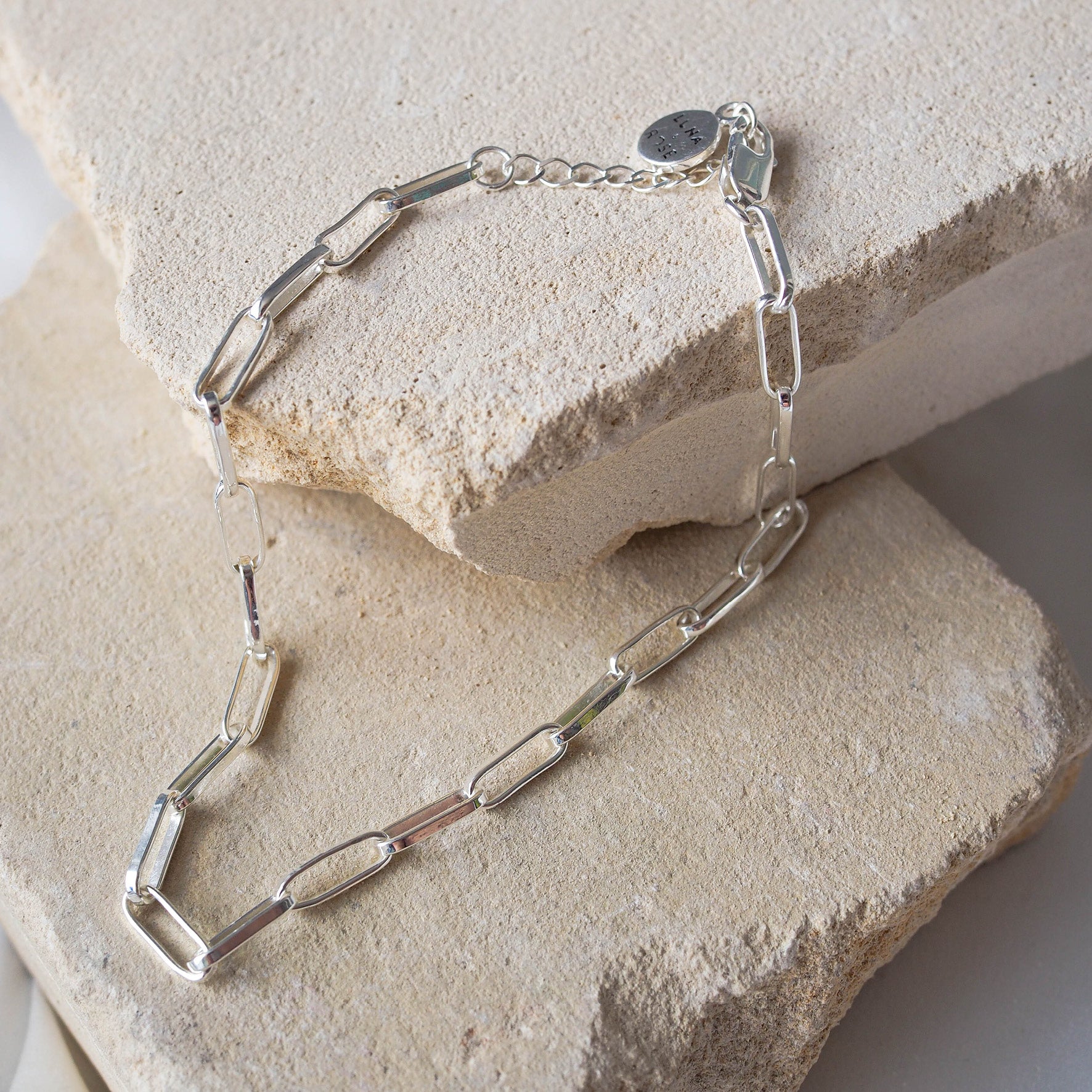 Washington Paper Clip Anklet - Silver displayed on beige stone