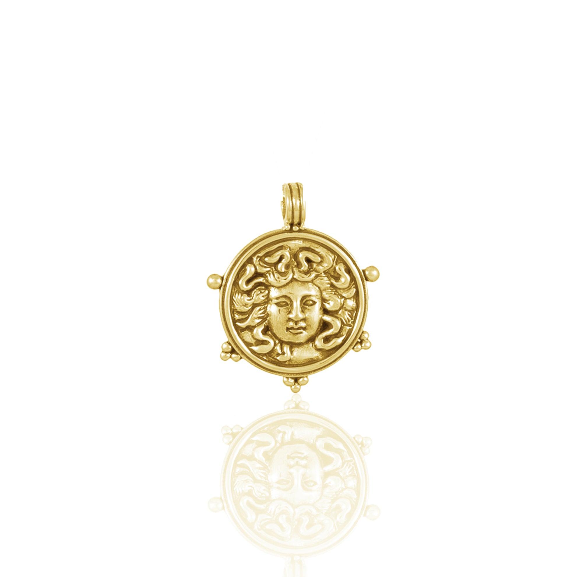 Gold pendant featuring a detailed Medusa face design with reflective surface.
