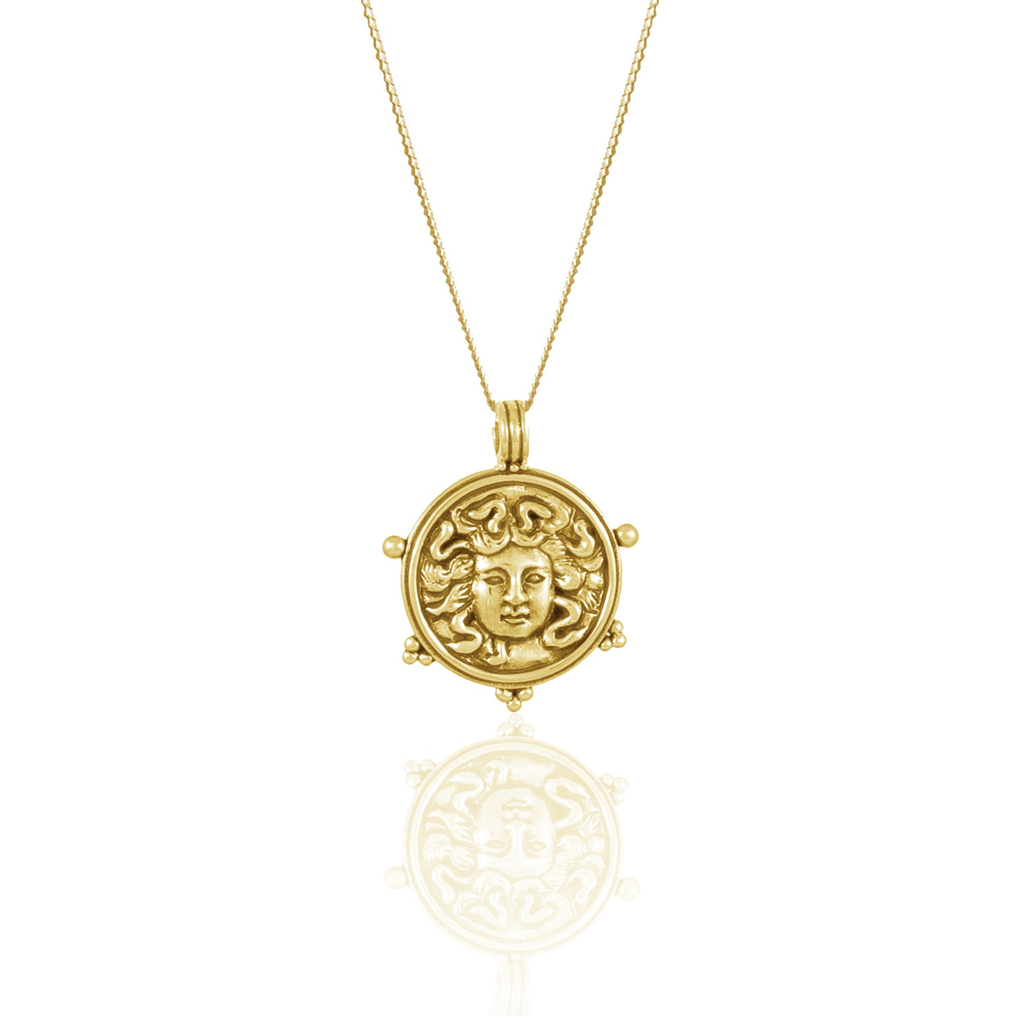 Gold necklace with pendant featuring a detailed Medusa face design with reflective surface