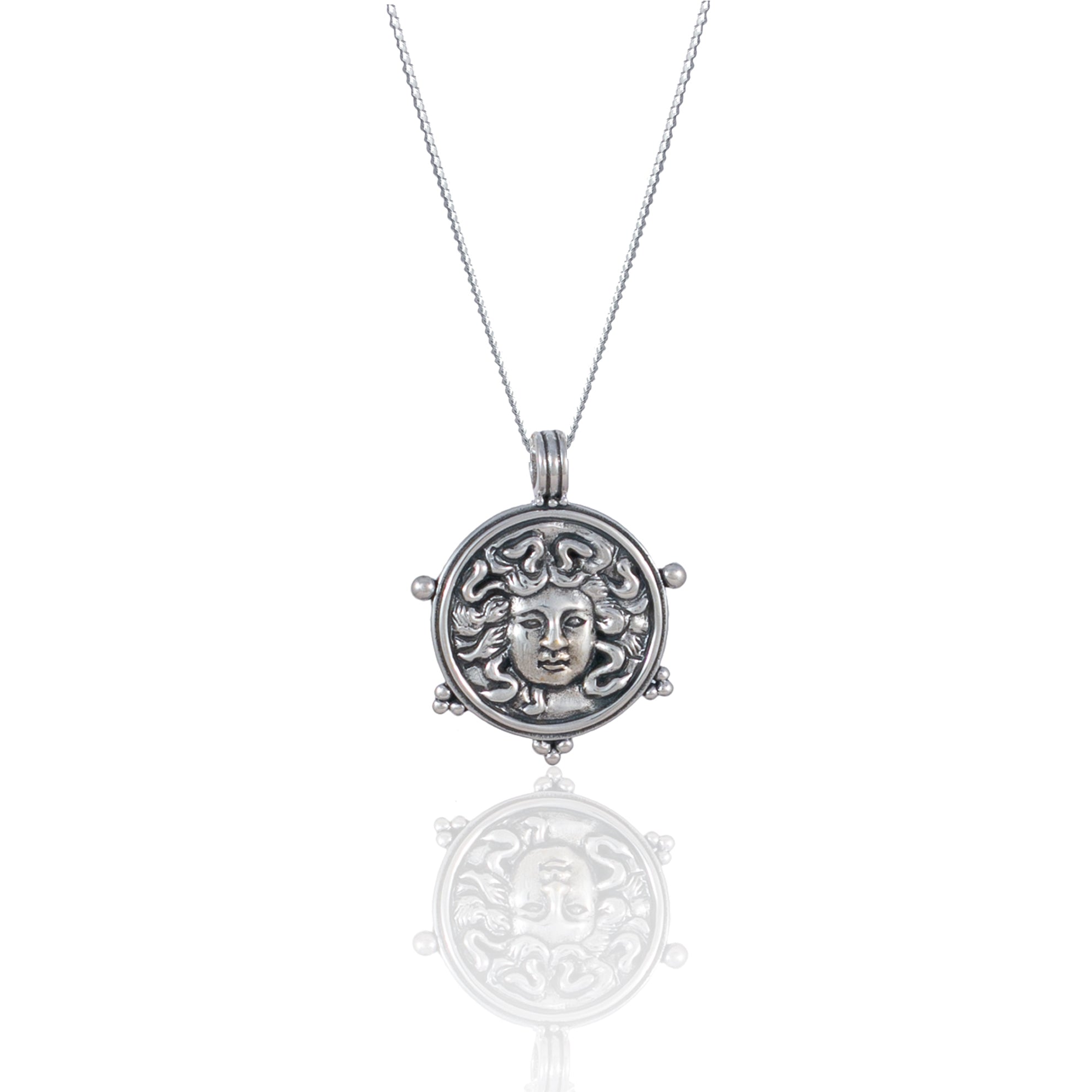 Silver necklace with pendant featuring a detailed Medusa face design with reflective surface.