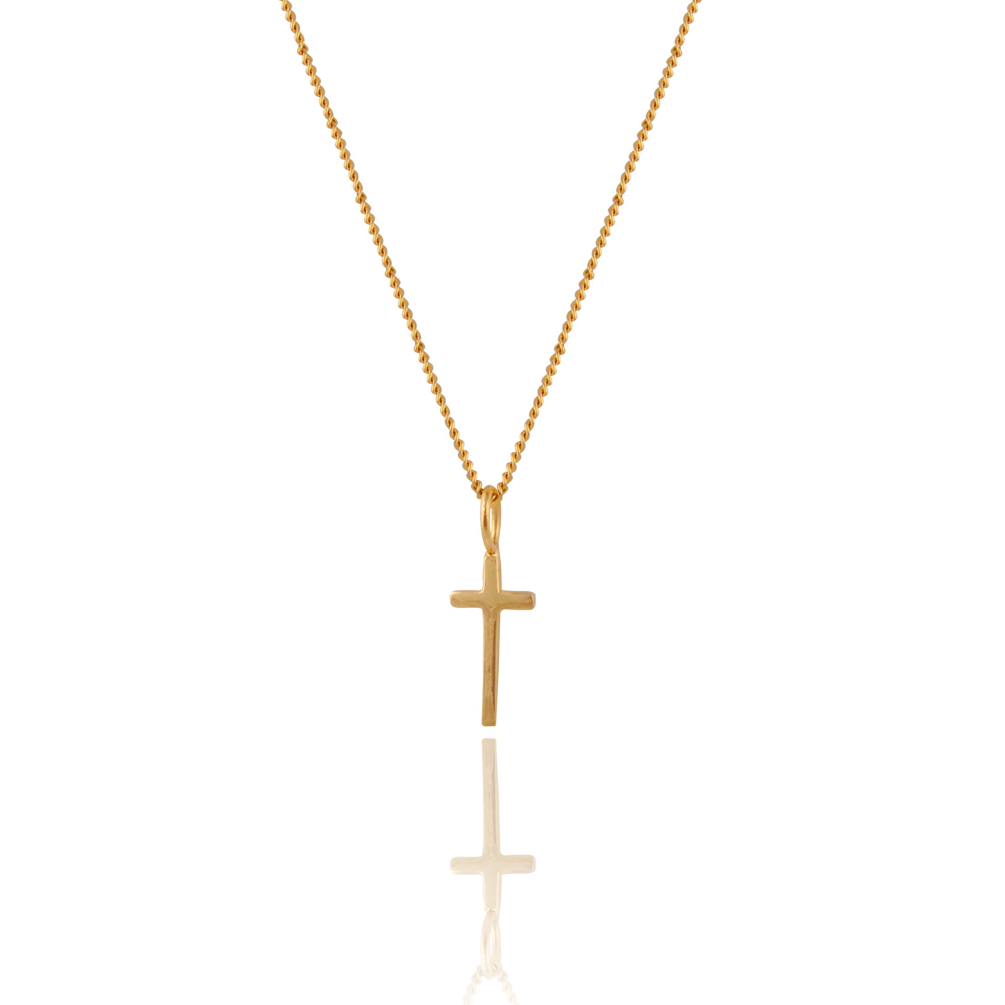 A gold necklace with a small cross pendant on a reflective surface.