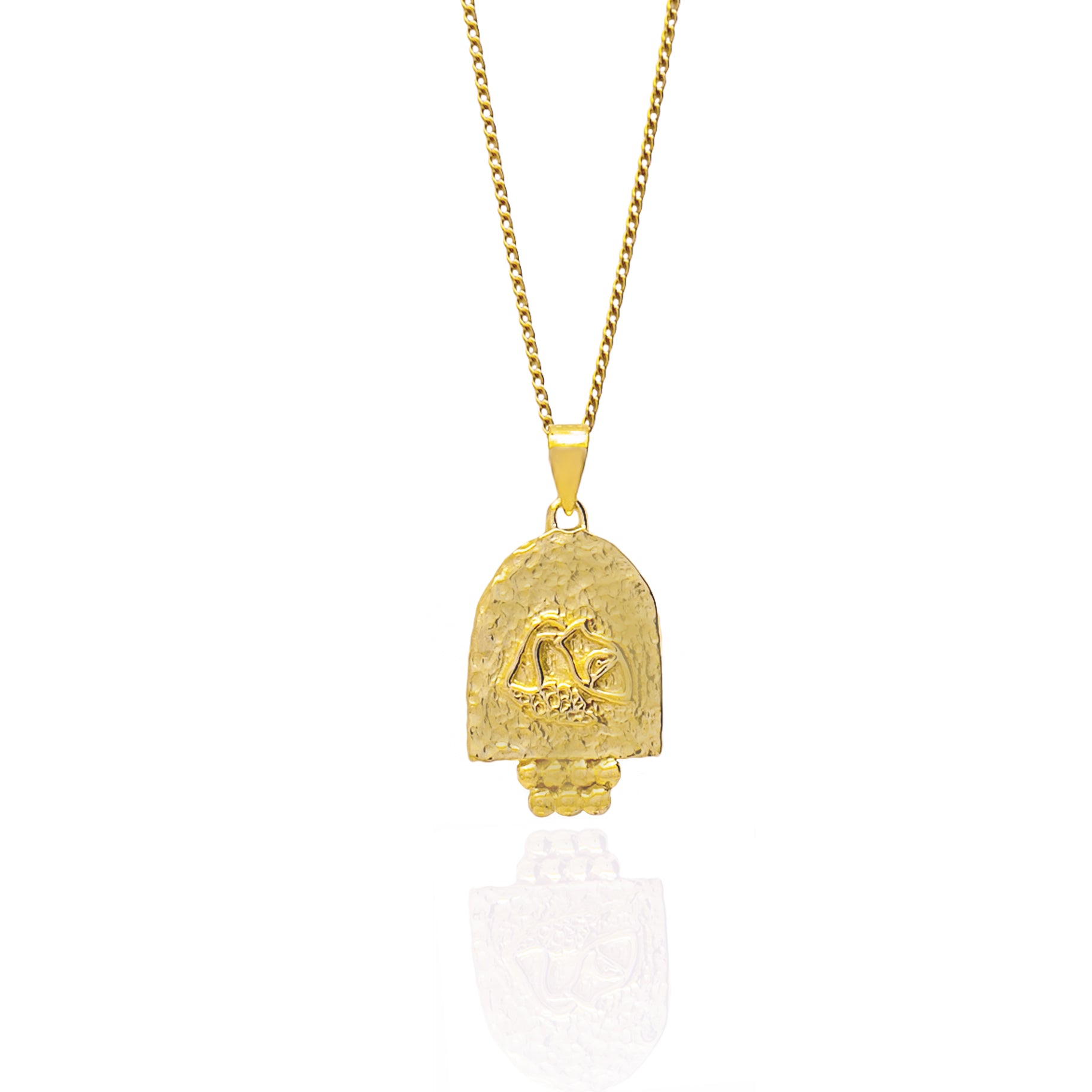 A gold pendant featuring an engraved design on a white background.