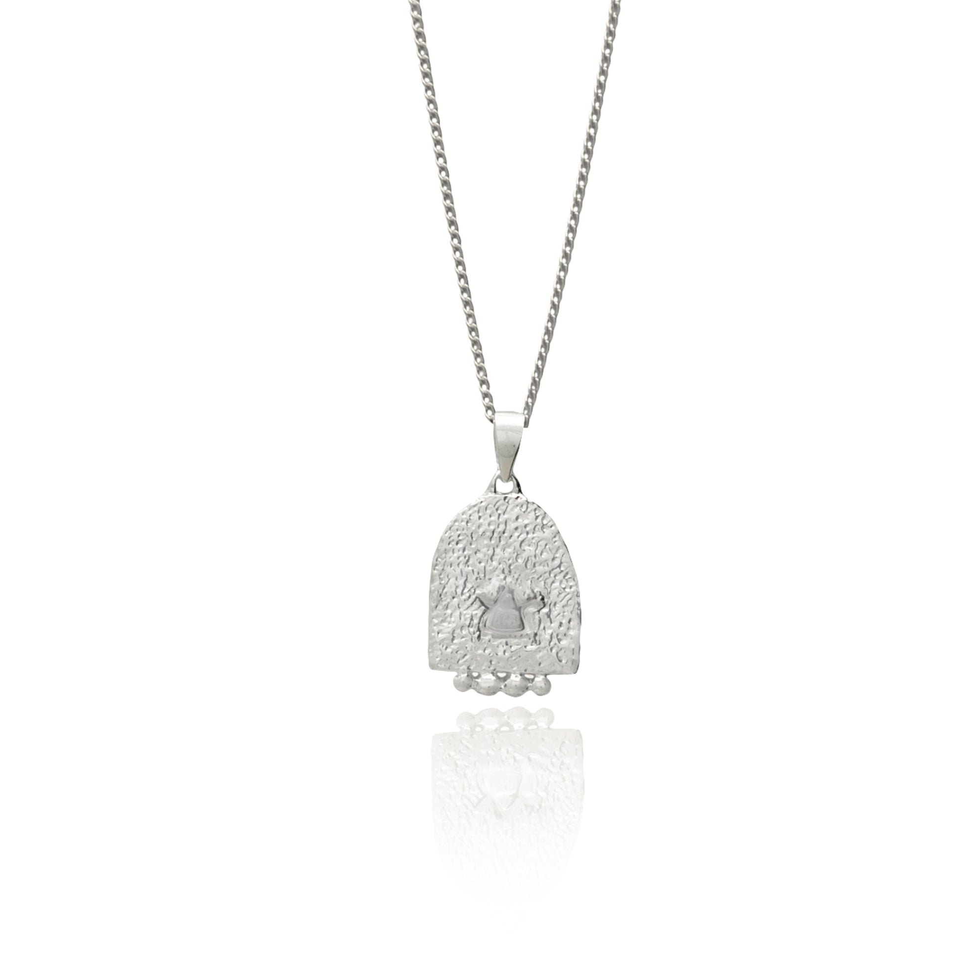 The back of a silver pendant featuring an engraved design on a white background.