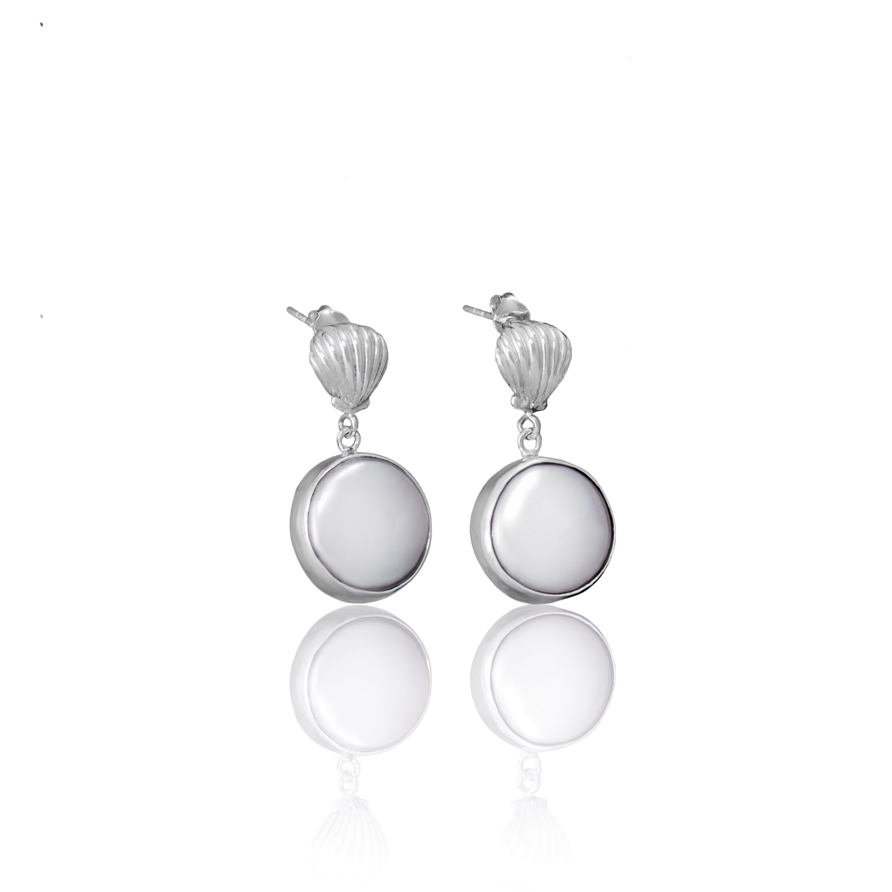A pair of silver shell earrings with large white pearl pendants against a white background.