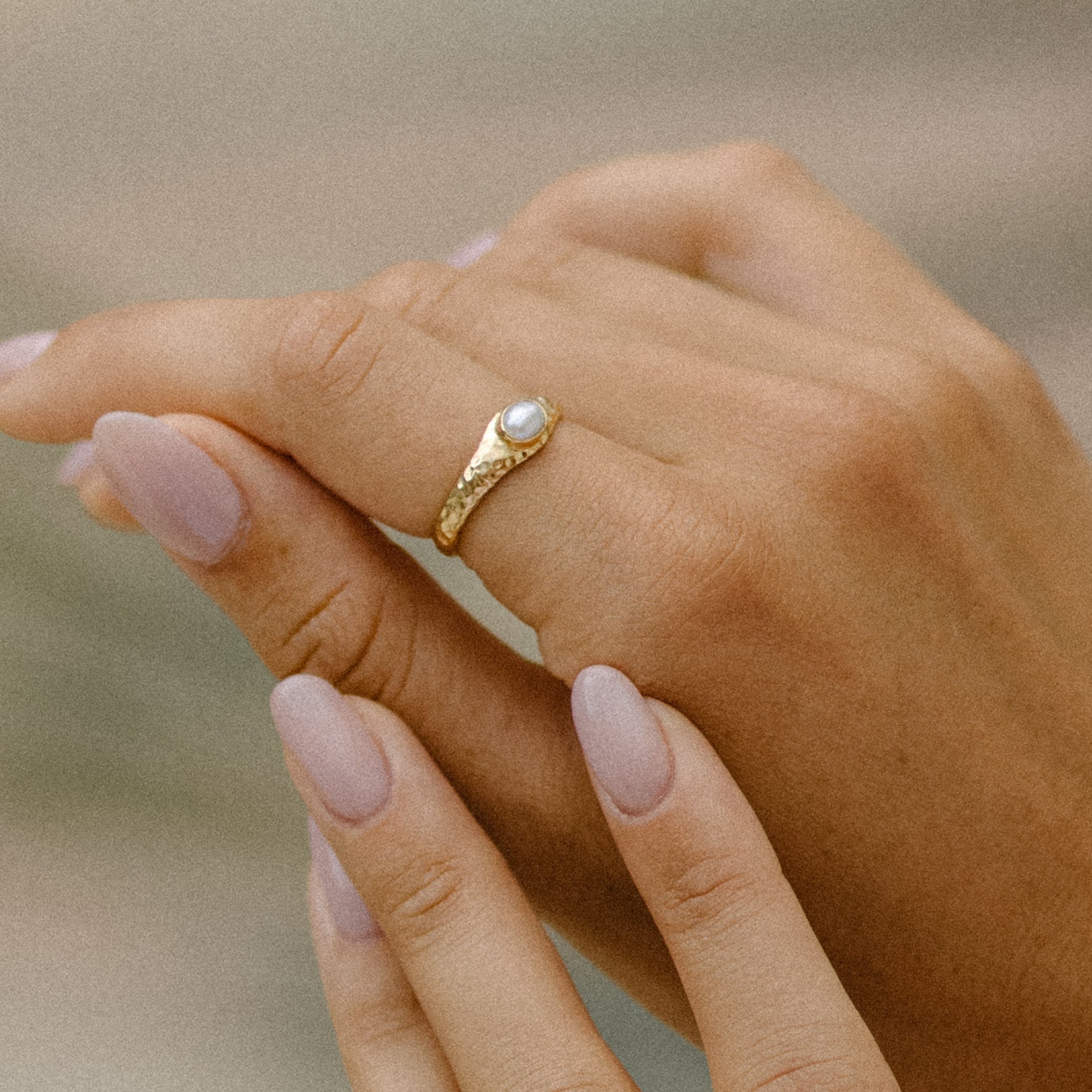 a woman worn Pia single pearl ring in gold on her finger