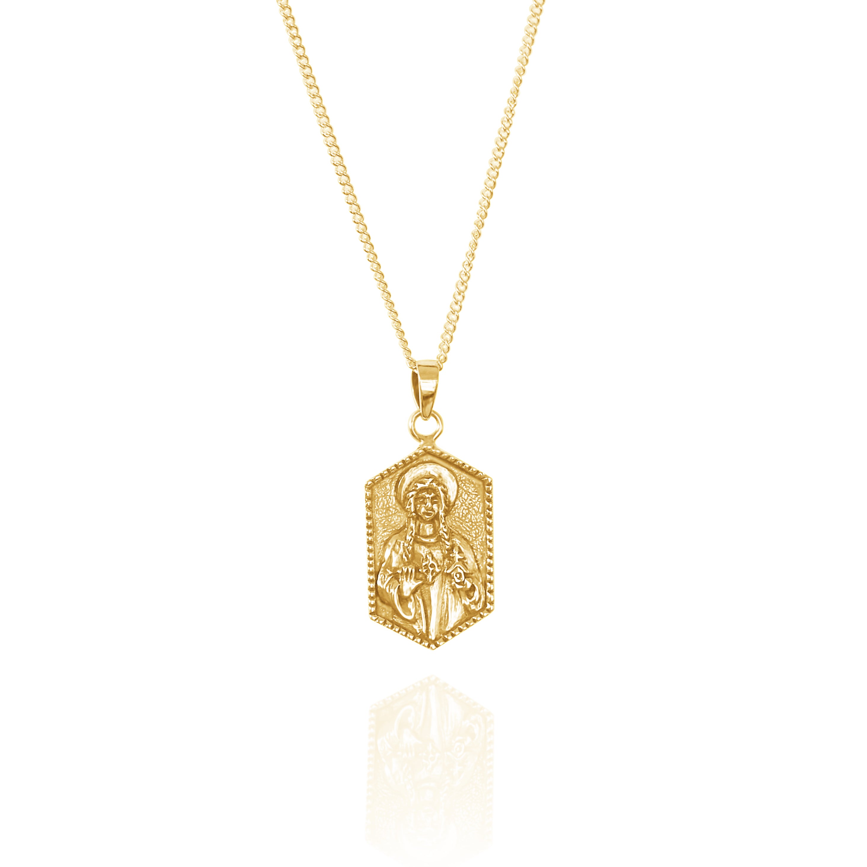 A gold necklace with a hexagonal pendant featuring a raised religious figure design, displayed against a white background.