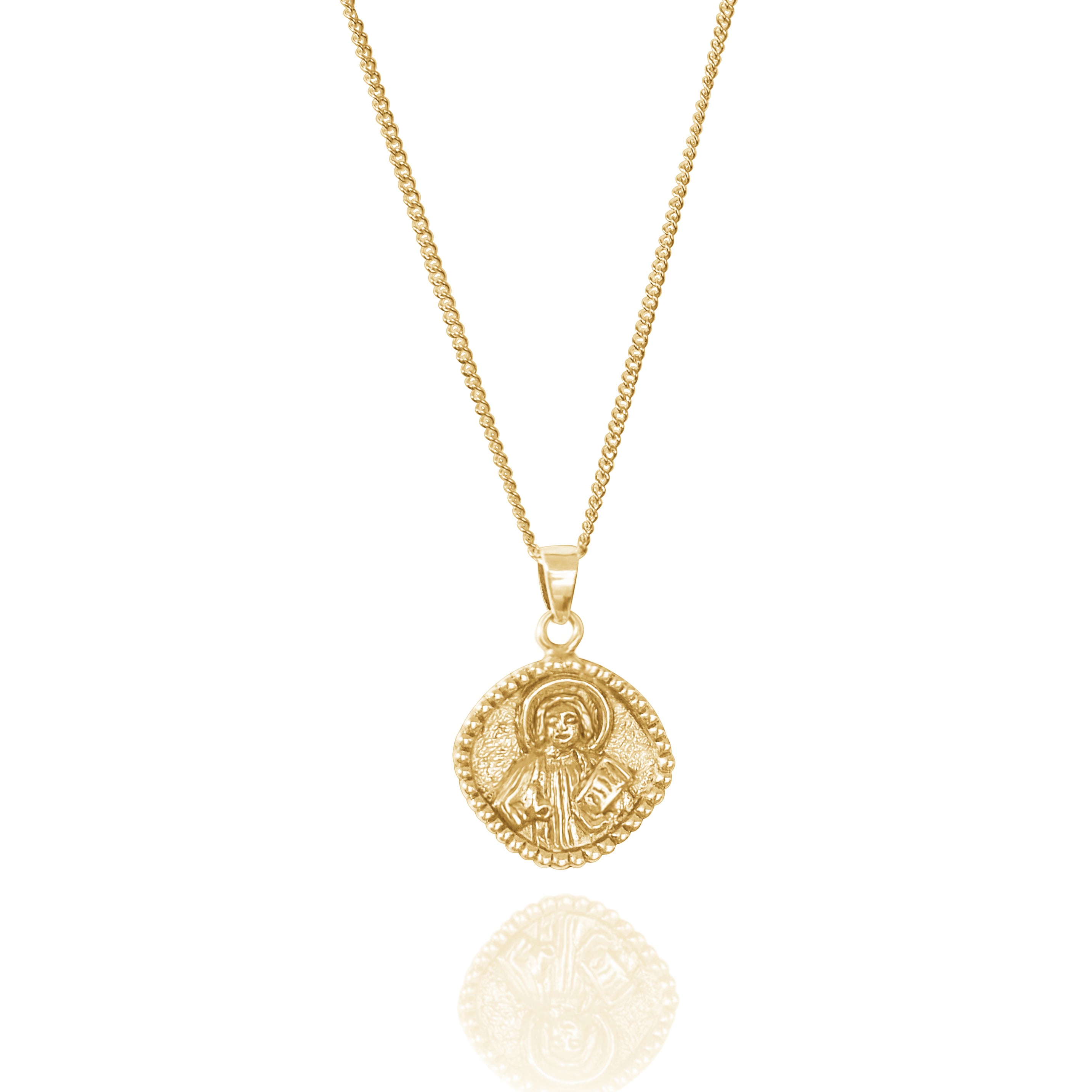 A gold necklace with a round pendant featuring a raised religious figure design, displayed against a white background.