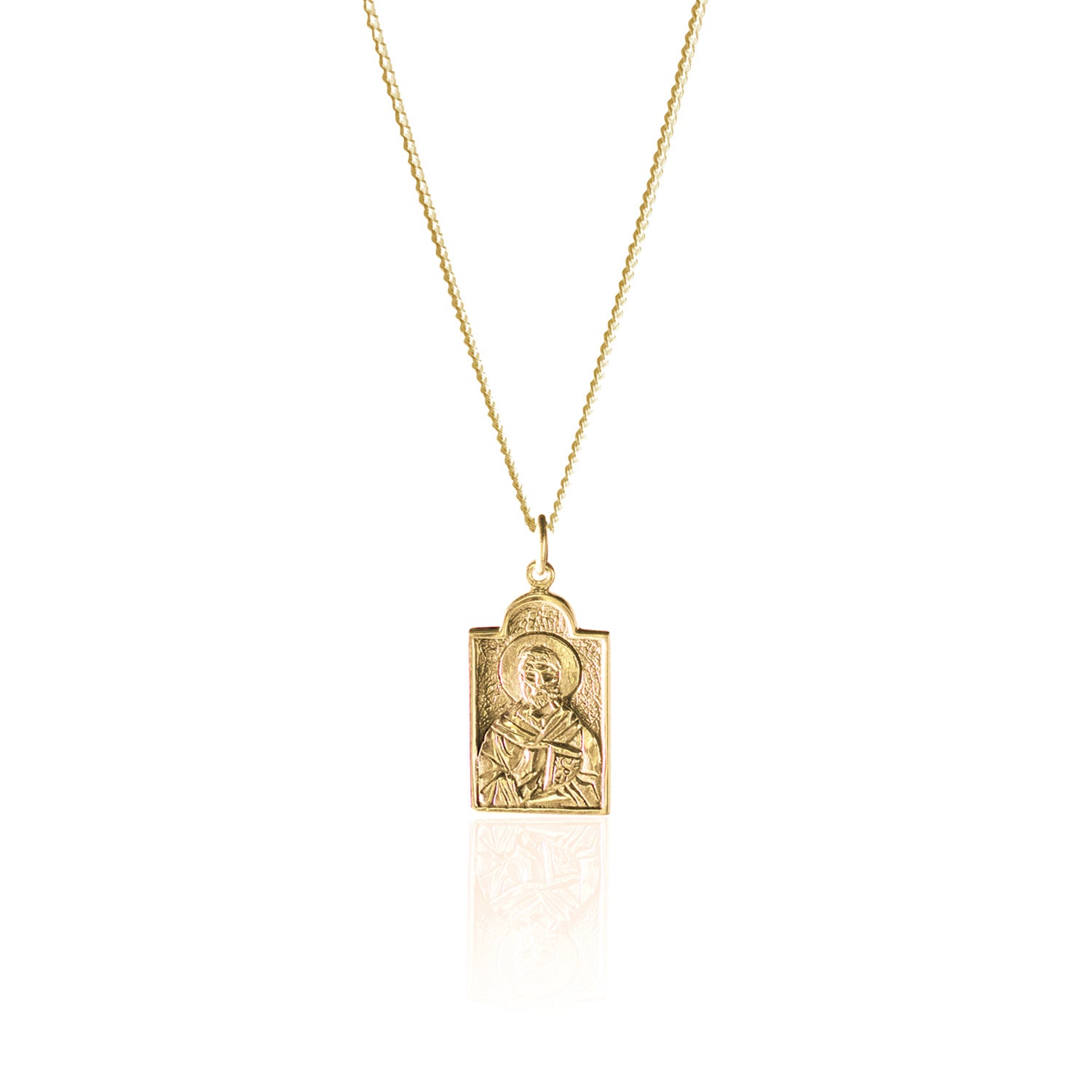 A gold necklace with a rectangular pendant featuring a raised religious figure design, displayed against a white background.