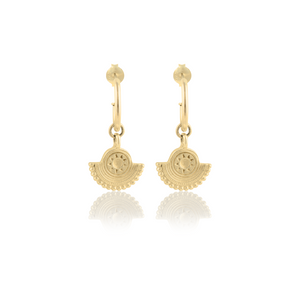 A pair of gold earrings with a circular sunburst design on a white background.