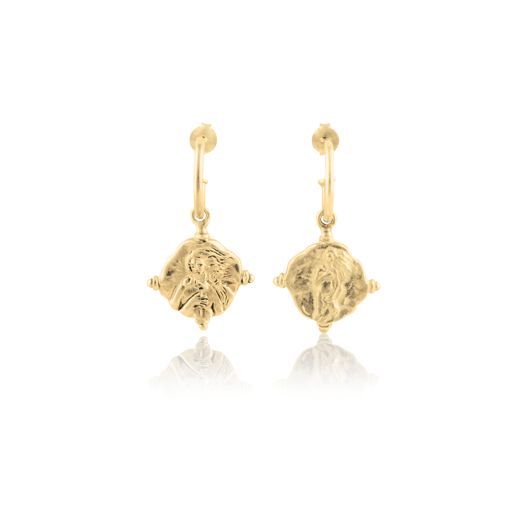 A pair of gold hoop earrings featuring religious figure designs on hanging charms.