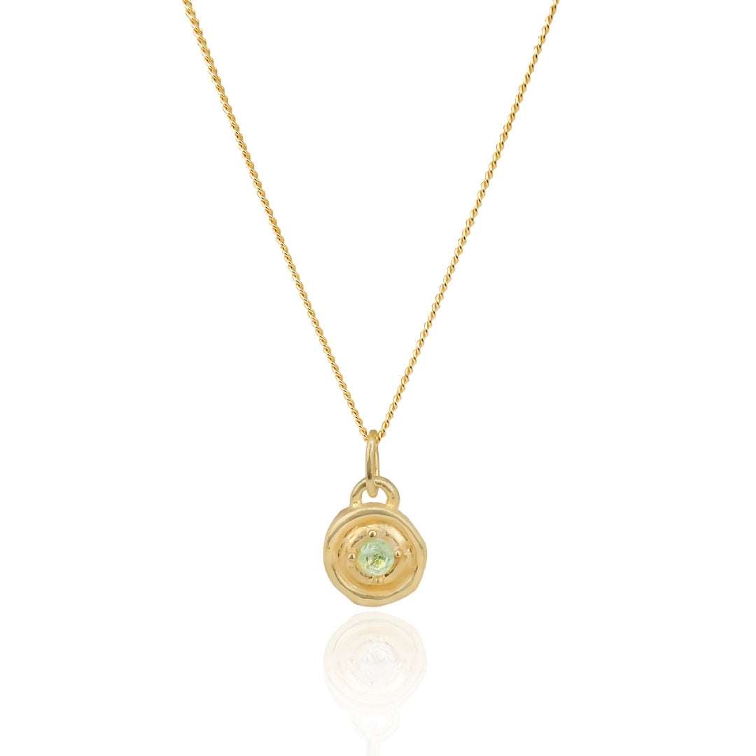 Gold necklace with a black pendant on a white background