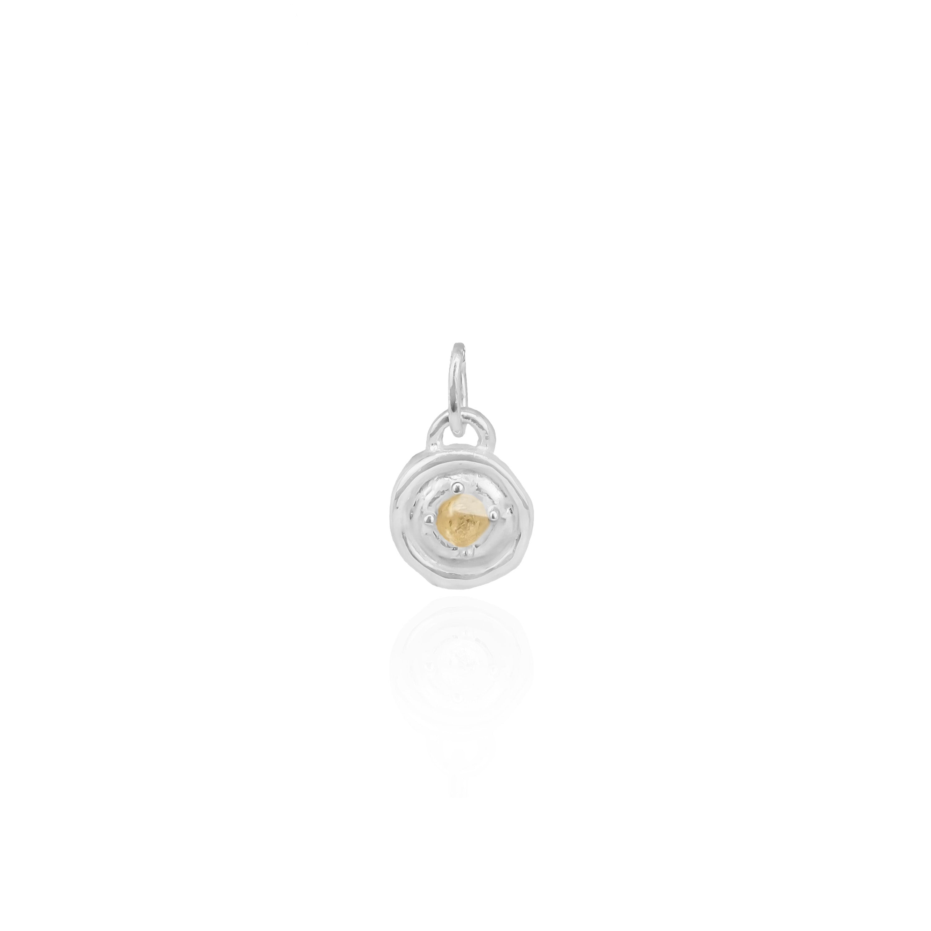 Silver pendant with a yellow gemstone on a white background