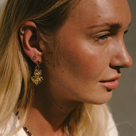 Close-up of gold jewelry glowing in sunlight on a woman