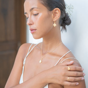 A woman wearing multiple golden jewellery looking down