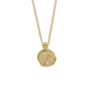 A gold necklace with a coin-shaped pendant featuring an engraved figural design, displayed on a white background.