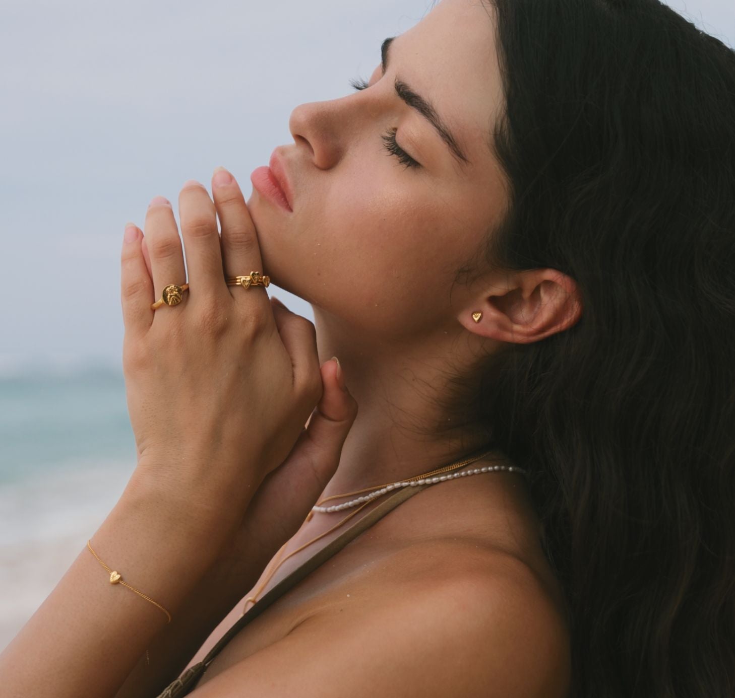 Girl wearing mini love heart rings stacked on her fingers at the beach in Bali