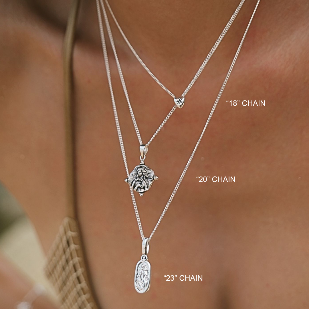Three silver necklaces with pendants on a person's neck, labeled with chain lengths.